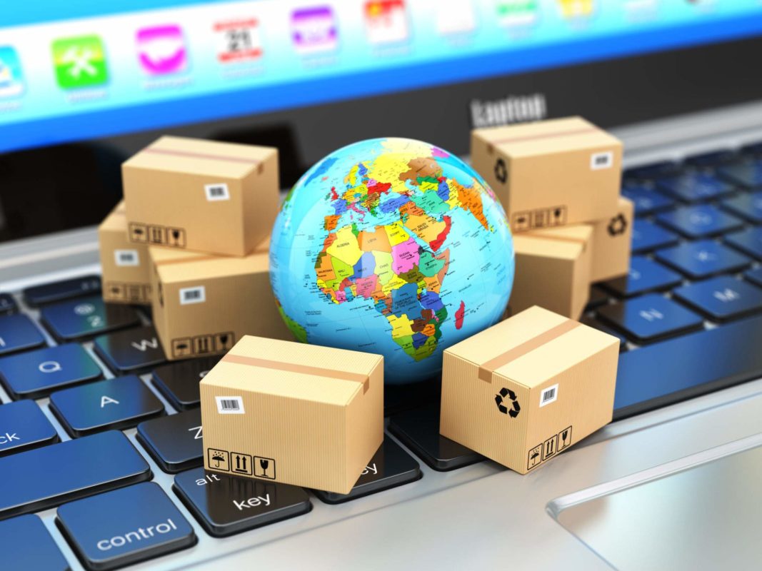 Shipping, delivery and logistic concept. Earth and cardboard boxes on laptop keyboard. Online technology. 3d